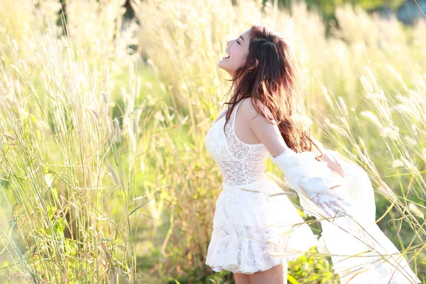Portrét nádherné ženy, která má šťastné chvíle a baví se mezi travnatými poli v přírodě — Stock fotografie
