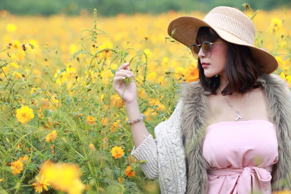 Ragazza carina e bella con cappello in piedi nella natura all'aperto tra il campo di fiori cosmo (tempo di riposo sul concetto di vacanza ) — Foto Stock