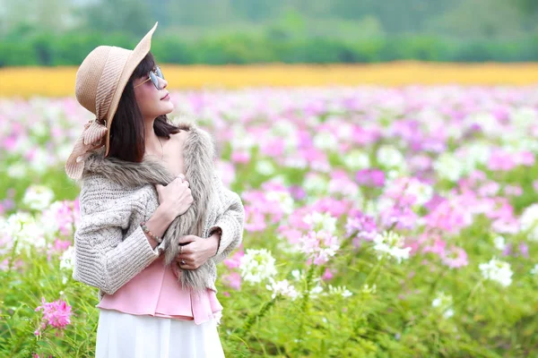 Schattig en mooi meisje met hoed staande in de natuur buiten Cosmos bloemen veld (rusttijd op vakantie concept) — Stockfoto