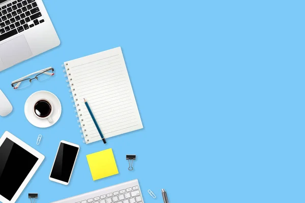 Werkruimte tabel met laptop computer, kantoorbenodigdheden, koffie kopje, mobiele telefoon en koffie kopje op blauwe pastel achtergrond — Stockfoto