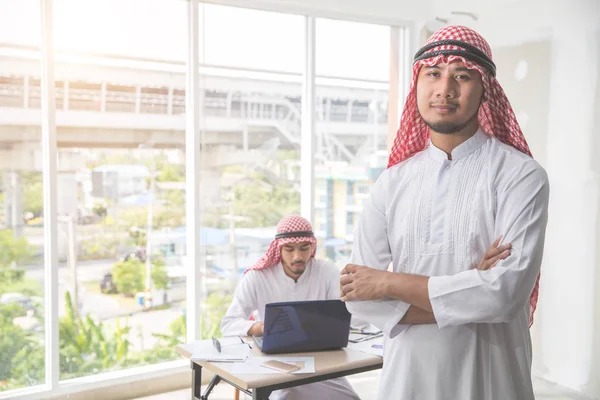 Arabisk saudisk affärsman porträtt med medarbetar bakgrund — Stockfoto