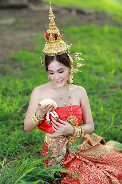 Mode asiatique fille en thaï costume traditionnel dans l'ancien temple avec volant fleur à la main — Photo