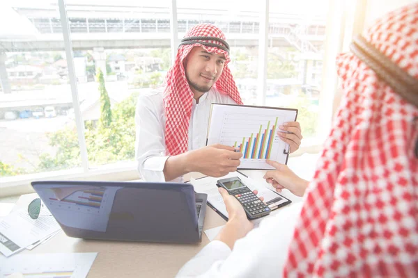 Arab Saudi affärsman arbetar och diskuterar med graf och kalkylator i Office — Stockfoto
