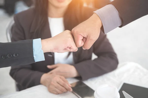 Affärsfolk ger knytnäve bump efter avslutat projekt under mötet med som bakgrund (begreppet teamwork och partnerskap) — Stockfoto