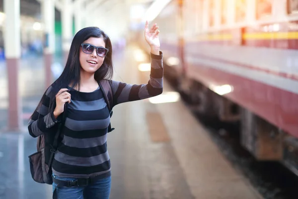 Ung reisende kvinne med ryggsekk som venter på toget – stockfoto