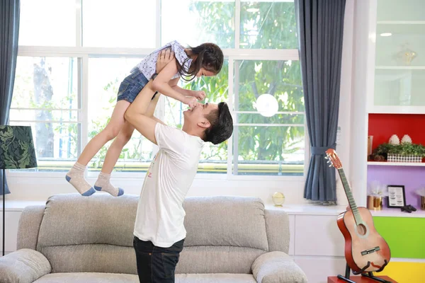 Mutlu Asyalı baba, gülümseyen yüzüyle oturma odasında dikilirken kızını kusar.)