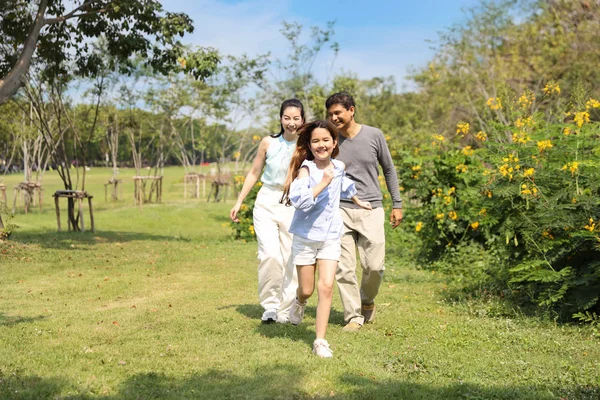 幸福的家庭父母和孩子在暑假期间在公园里散步和跑步，在晴朗的蓝天和绿树下休息 — 图库照片