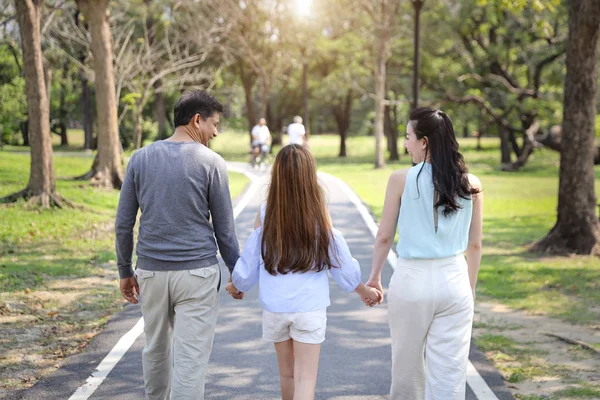 Lyckliga familje föräldrar och barn vilar genom att gå och springa i parken under sommarsäsongen med klarblå himmel och gröna träd — Stockfoto