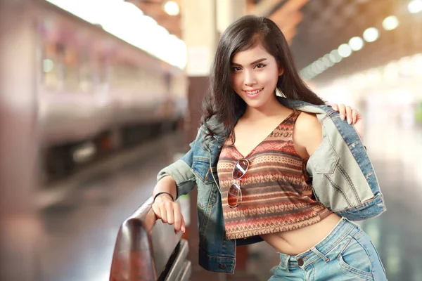 Tren için bekleyen ceket jean ile genç gezgin kadın — Stok fotoğraf