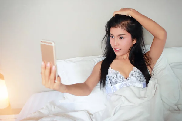 Giovane e sexy donna utilizzando il cellulare fare autoritratto — Foto Stock