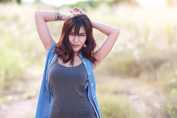 Young and cute girl having a happy time and enoying amoung grass field in nature — Stock Photo, Image