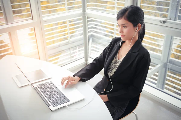 business woman take a break from completed work by listing music with sun light effect