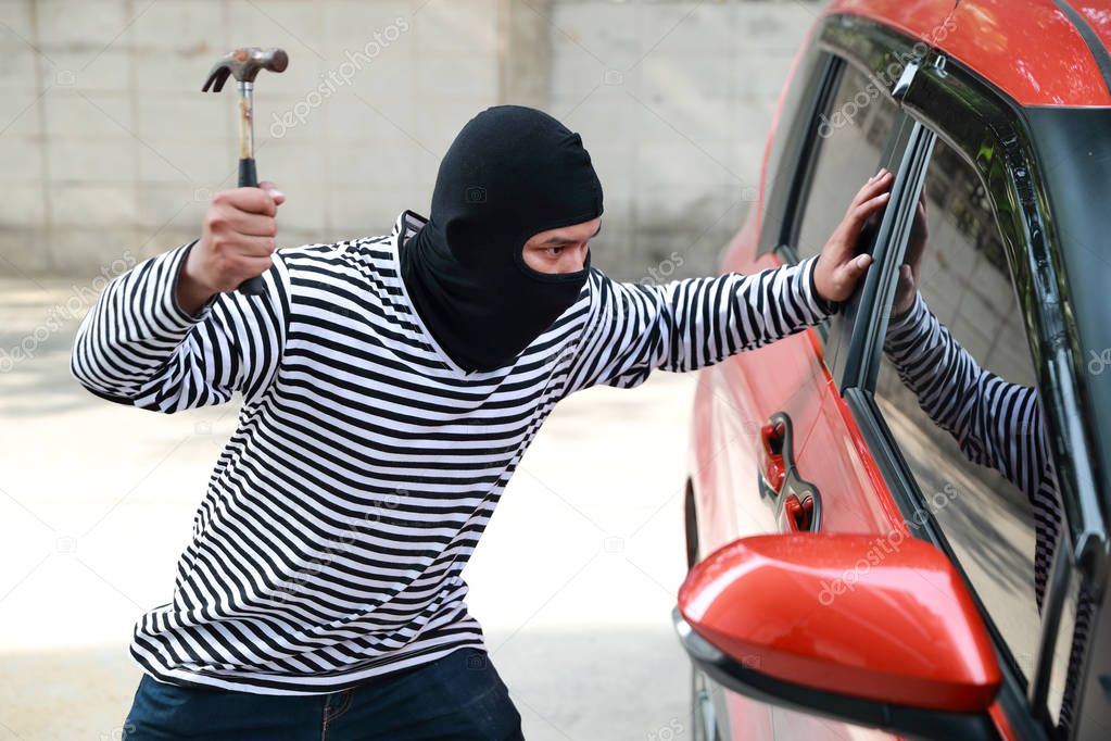 thief try to break into car with hammer (theft concept)