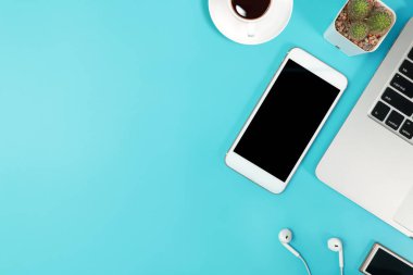 bilgisayar, akıllı telefon, kahve fincanı, kulak telefonu ve kaktüs ile iş masası üst görünümü