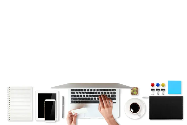 Table de travail de technologie avec des mains de femme sur ordinateur portable, carte de crédit, tasse à café et téléphone portable sur fond blanc (ou shopping et paiement concept en ligne ) — Photo