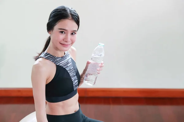 Spor salonunda genç sağlıklı ve sportif kadın içme suyu — Stok fotoğraf