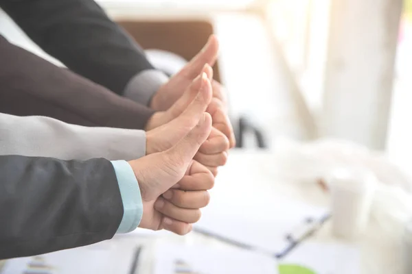 Affärsfolk ger tummen upp efter avslutade projekt under mötet med som bakgrund (begreppet teamwork och partnerskap) — Stockfoto