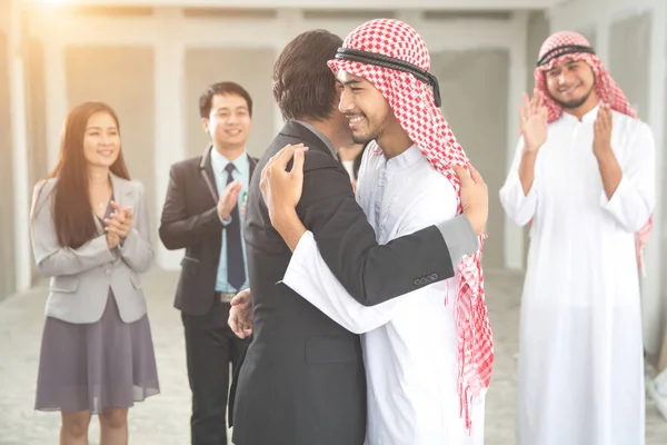 Arabisk saudisk affärsman kramar med företagare för framgångsrik affär med som affärsbakgrund (begreppet teamwork och partnerskap) — Stockfoto