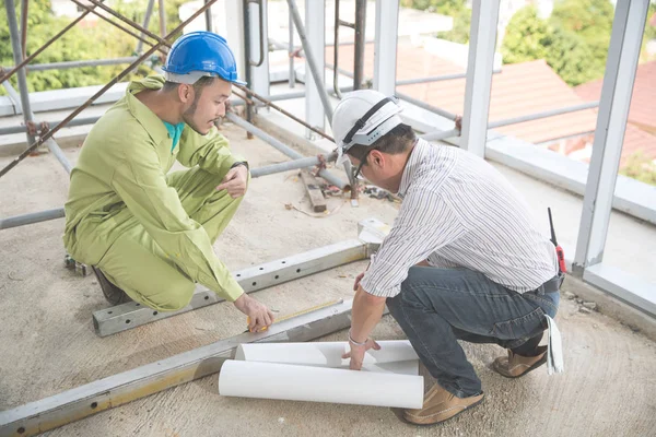 şantiyede mimarlık veya plan ile çalışan ve tartışan mühendis insanlar