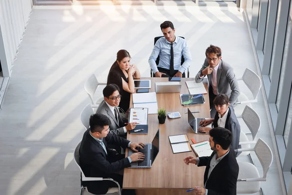 Utsikt från toppen av kaukasiska föreläsare ger offentlig presentation med företagets affärsdiagram resultat på White Board i mötesrum och multietniska affärsfolk uppmärksammar (utbildning eller seminarie koncept) — Stockfoto