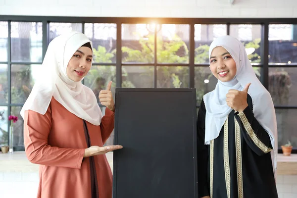 Meninas muçulmanas jovens mostrando placa preta e polegar para cima (você pode colocar letra sobre ele ) — Fotografia de Stock