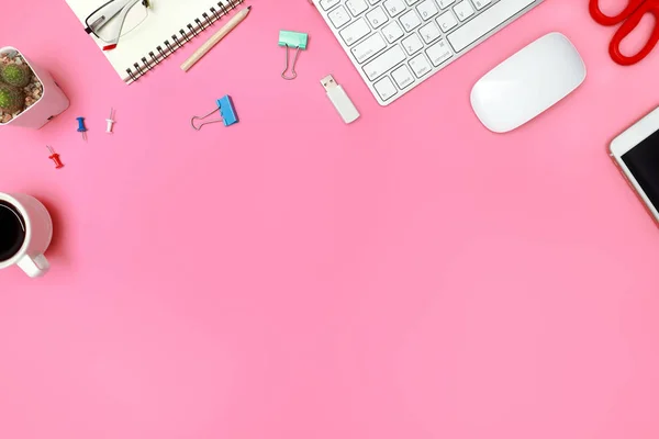Widok z góry lub płaski różowy pastelowy biurko z komputerem, materiałami biurowymi i filiżanką kawy — Zdjęcie stockowe