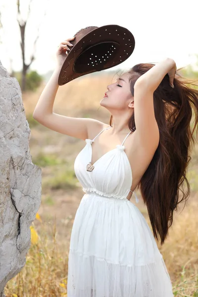 Мила і красива дівчина, що стоїть на природі на відкритому повітрі з капелюхом — стокове фото