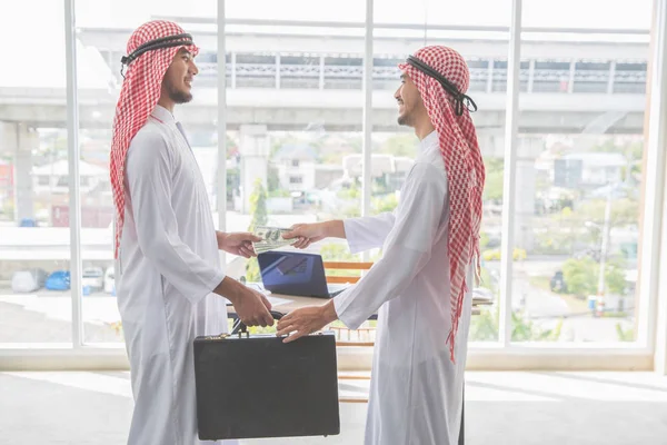 Arab Saudi affärsman ta emot pengar för framgångsrik affär med som affärsbakgrund (begreppet teamwork och partnerskap) — Stockfoto