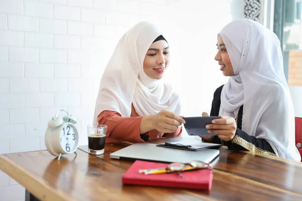 Uomini d'affari musulmani di nuova generazione che si incontrano in caffetteria con computer, calcolatrice e tazza di caffè sulla scrivania in legno — Foto Stock