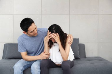 Genç koca koltukta otururken omuzlarını rahatlatıyor ve ona dokunuyor.