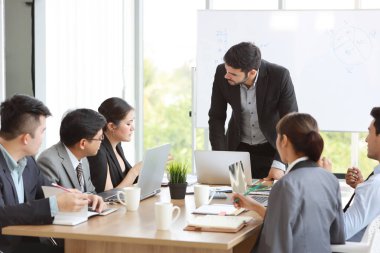 Şirket işletme grafiği ile kamuoyu sunumu yapan Kafkas öğretim üyesi toplantı odasında beyaz yönetim kuruluna sonuç verdi ve çok ırklı iş adamları dikkat ediyor (eğitim veya seminer konsepti))