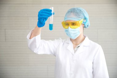 kimyasal sıvı tutan ekipman ve laboratuvar cam ile bilim adamı kadın ve bilim araştırma arka plan olarak kullanarak sonuç kontrol