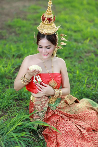 Moda asiático chica en tailandés tradicional traje en antiguo templo con volante flor en la mano — Foto de Stock