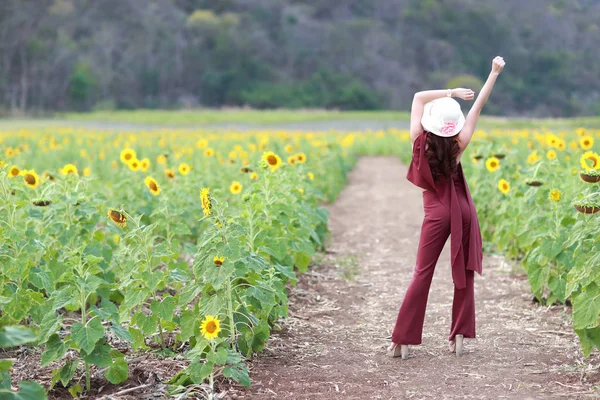 Портрет красивої жінки, яка має щасливий час і насолоджується серед соняшникового поля в природі — стокове фото