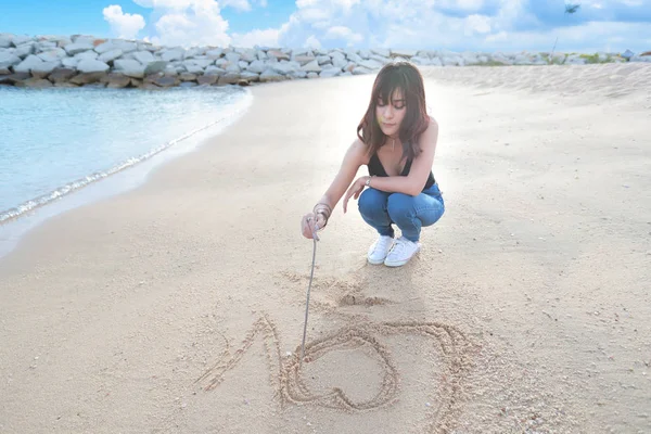 Portrait de belle femme écrivant amour sur la plage de sable — Photo