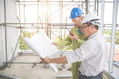 şantiyede mimarlık veya plan ile çalışan ve tartışan mühendis insanlar