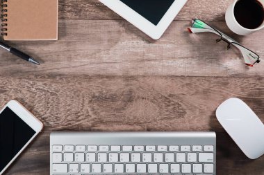 bilgisayar, kahve fincanı, dizüstü bilgisayar, akıllı telefon, ofis malzemeleri ve cep telefonu ahşap arka plan ile düz ray veya üst görünüm çalışma alanı iş masası