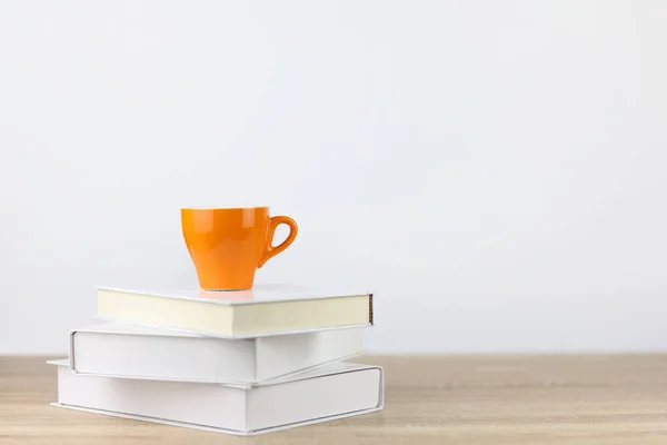 Xícara de café com livros em mesa de madeira e fundo branco — Fotografia de Stock