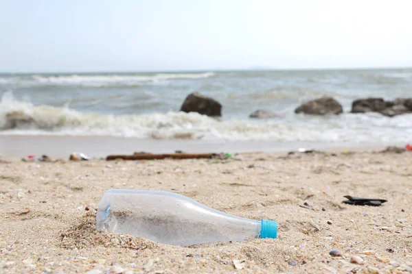 肮脏海滩上空塑料水瓶的特写图片，在肮脏的沙滩上充满了塑料污染、垃圾和垃圾 — 图库照片