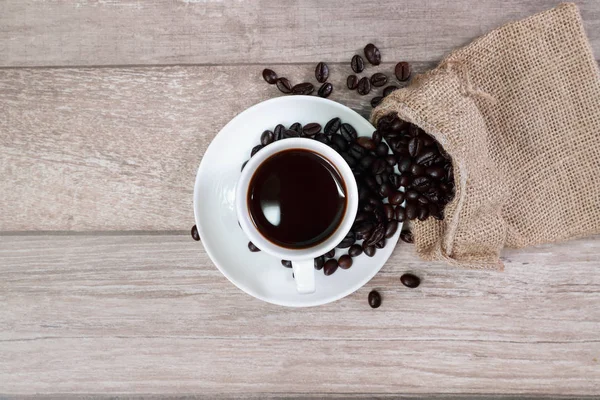 Tazza di caffè e chicco di caffè sulla scrivania in legno — Foto Stock