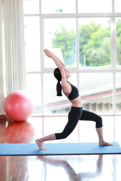 Sportief meisje beoefenen van yoga en stretching in de sportschool — Stockfoto