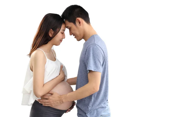 Giovane marito in piedi e abbracciando giovane moglie ventre incinta con felicità e sorriso isolato e sfondo bianco — Foto Stock