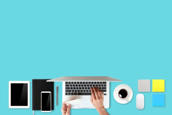 Technology working table with woman hands on laptop computer, credit card, coffee cup and cell phone on green background (or shopping and payment online concept) — Stock Photo, Image