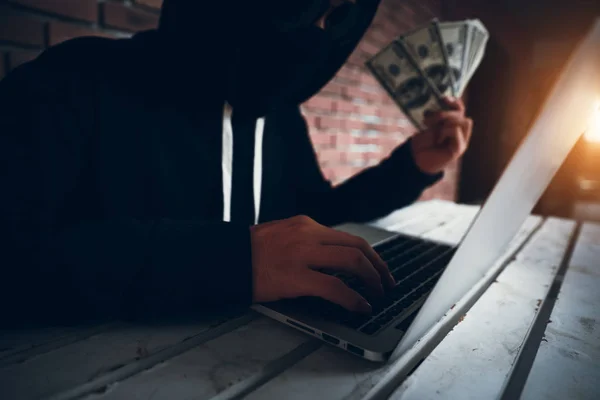 Хакер пытается взломать и украсть данные информационной системы с компьютера и показать деньги после взлома — стоковое фото