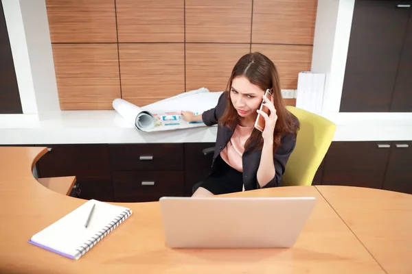 Bizneswoman zajęty papierową pracą z komputerem i telefonem komórkowym na stole — Zdjęcie stockowe