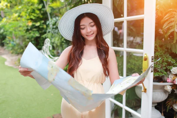年轻和可爱的亚洲女人在假期期间在地图中搜索位置 — 图库照片