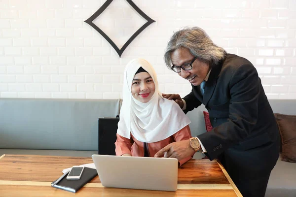 Muslim businessman meeting with businesswoman using laptop computer and smart phone — Stock Photo, Image