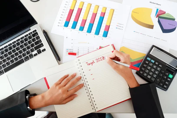 Geschäftsfrau schreibt Geschäftsziel für 2018 auf Notizbuch — Stockfoto