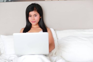 uykuya dalmadan önce yatakta dizüstü bilgisayar kullanarak güzel ve seksi kadın