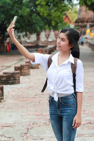 Genç Asyalı gezgin cep telefonu kullanarak ve tatil tatili sırasında seyahat ederken tapınakta kendi portre yapmak — Stok fotoğraf